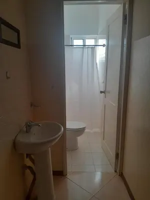 a white bathroom with a toilet and a sink at Casa Magui e Cláudio in Tarrafal