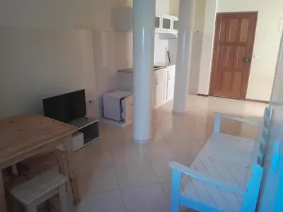 a kitchen with a table and a dining room at Casa Magui e Cláudio in Tarrafal