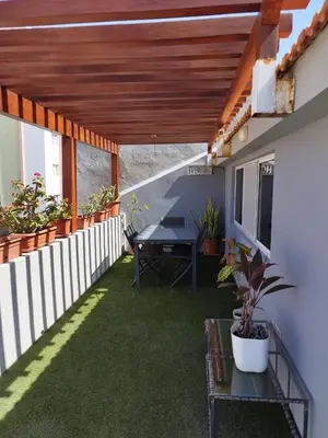 a patio with a table and a fence at Apartamento T1, amplo e arrejado in Praia