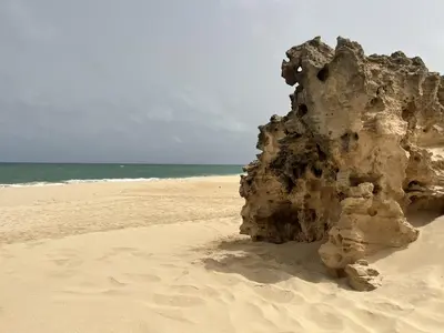 a rock in the sand on a beach at Apartment Boadventure in Sal Rei