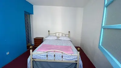 a small bedroom with a bed with a pink blanket at Pensão Rilda Montrond in Portela