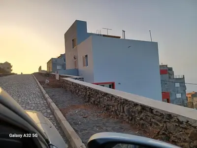 a white building on the side of a road at Casa Larinha in Ponta do Sol