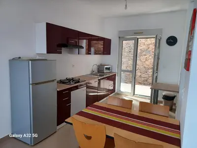 a small kitchen with a table and a counter top at Casa Larinha in Ponta do Sol