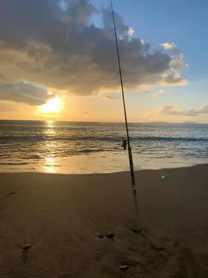 a fishing pole on the beach with the sunset at Ca Azul in Tarrafal