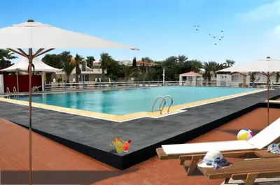 a swimming pool with two chairs and an umbrella at Studio Murdeira Side Beach, Eco Protected Bay, Pool in Beirona