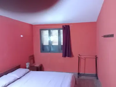 a red bedroom with a bed and a window at ApartamentoT1 Ponta do Sol in Ponta do Sol