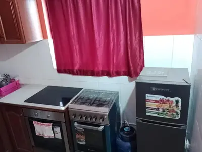 a kitchen with a stove and a red window at ApartamentoT1 Ponta do Sol in Ponta do Sol
