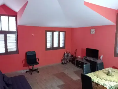 a living room with red walls and a table and chairs at ApartamentoT1 Ponta do Sol in Ponta do Sol