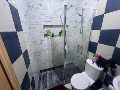 a bathroom with a shower with a toilet at Cozy kriol stay, steps to ocean in Praia