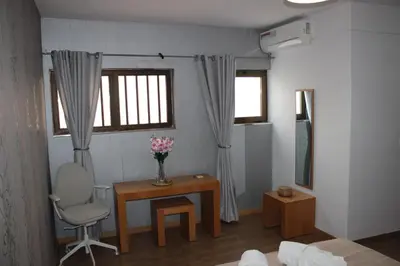 a room with a desk and a chair and a table with flowers at brISA in Praia