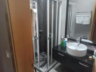 a bathroom with a glass shower and a sink at Relache House Praia in Praia
