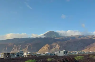 a view of a mountain range with houses and mountains at Cacimba Sunset Lodge in Tarrafal