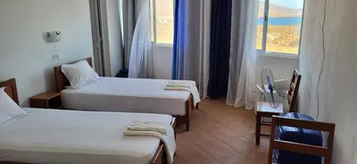a hotel room with two beds and a window at Cacimba Sunset Lodge in Tarrafal