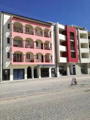 a pink and white building on the side of a street at Casa Sara Boavista in Sal Rei