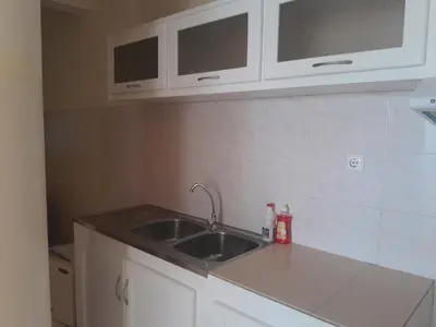a kitchen with a sink and white cabinets at Casa Magui de Reis in Tarrafal
