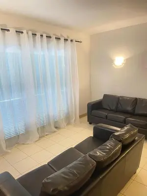 a living room with a leather couch and a window at Suíte Deluxe Soares in Prainha