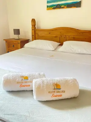 a bed with two towels sitting on top of it at Suíte Deluxe Soares in Prainha