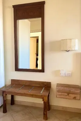 a mirror and a wooden bench in a room at Ocean & Pool - 2 bedroom Apartment in Santa Maria
