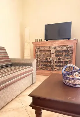 a living room with a couch and a flat screen tv at Ocean & Pool - 2 bedroom Apartment in Santa Maria