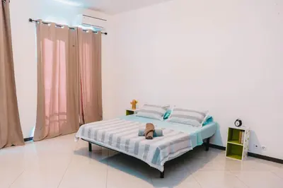 a bedroom with a bed with a purse on it at T2 amplo com ar condicionado e perto da praia in Praia