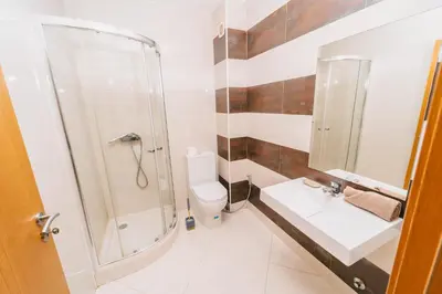 a bathroom with a shower and a sink and a toilet at T2 amplo com ar condicionado e perto da praia in Praia
