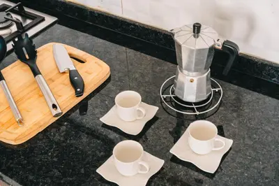 a kitchen counter with a blender and coffee cups at T2 amplo com ar condicionado e perto da praia in Praia