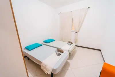 two beds in a room with a mirror at T2 amplo com ar condicionado e perto da praia in Praia