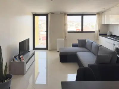 a living room with a couch and a tv at 1 bdr charming central apt in Praça Center - LCGR in Praia