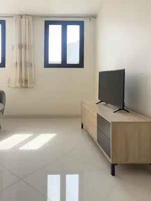 a living room with a flat screen tv on a wooden cabinet at 1 bdr cozy central apt in Praça Center - LCGR in Praia