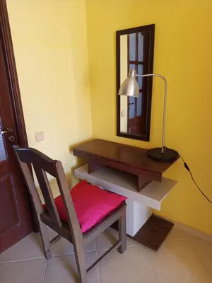 a desk with a chair and a lamp and a mirror at Appartamento Gianni in Santa Maria