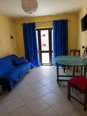 a living room with a blue couch and a table at Appartamento Gianni in Santa Maria