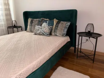a bed with a green headboard and pillows on it at Prainha Beach House in Praia