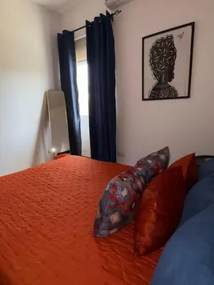 a bedroom with a bed with orange sheets and pillows at Prainha Beach House in Praia