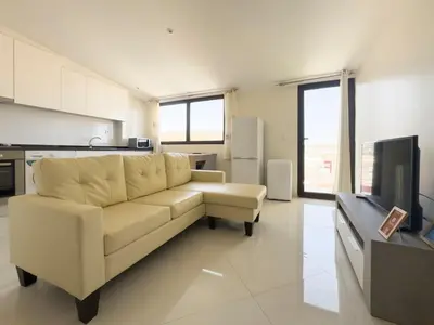 a living room with a white couch and a television at 2 bdr charming central apt in Praça Center - LCGR in Praia