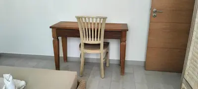 a wooden table with a chair next to a door at Girasole Apartments in Sal Rei