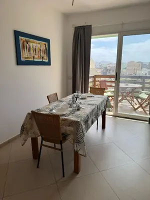 a dining room with a table with chairs and a window at Girasole Apartments in Sal Rei