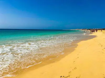 a group of people walking on the beach at Morabeza Vila Verde in Santa Maria