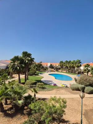 an overhead view of a swimming pool with palm trees at 3 Bedroom property in Paradise Beach in Santa Maria