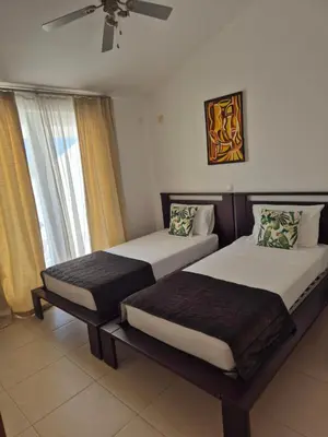 a bedroom with two beds and a ceiling fan at 3 Bedroom property in Paradise Beach in Santa Maria