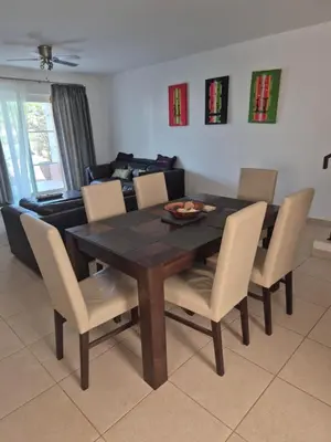 a dining room table with chairs and a couch at 3 Bedroom property in Paradise Beach in Santa Maria