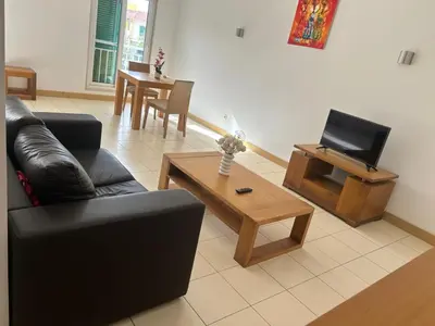 a living room with a couch and a tv and a table at Vila Verde Calistemon in Santa Maria