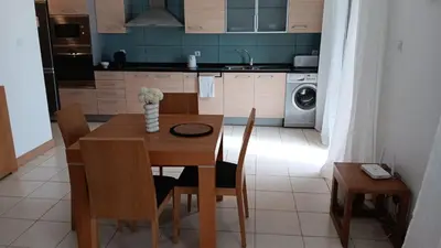 a kitchen with a wooden table with chairs and a dining room at Vila Verde Calistemon in Santa Maria