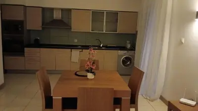 a kitchen with a wooden table with chairs and a dining room at Vila Verde Calistemon in Santa Maria