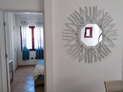 a mirror hanging on a wall in a hallway at Greta Apartment in Santa Maria