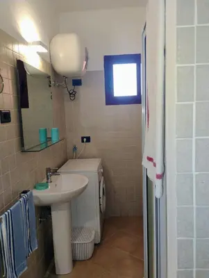 a small bathroom with a sink and a mirror at Greta Apartment in Santa Maria