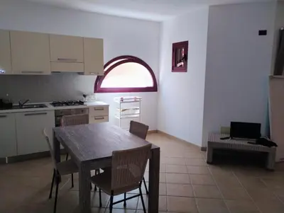 a kitchen with a table and chairs and a window at Greta Apartment in Santa Maria
