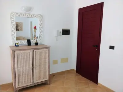 a room with a red door and a mirror at Greta Apartment in Santa Maria