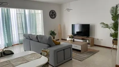 a living room with a couch and a tv at Appartement 3 chambres tout confort in Praia