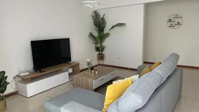 a living room with a couch and a flat screen tv at Appartement 3 chambres tout confort in Praia
