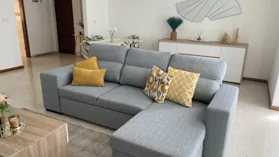 a living room with a blue couch with yellow pillows at Appartement 3 chambres tout confort in Praia